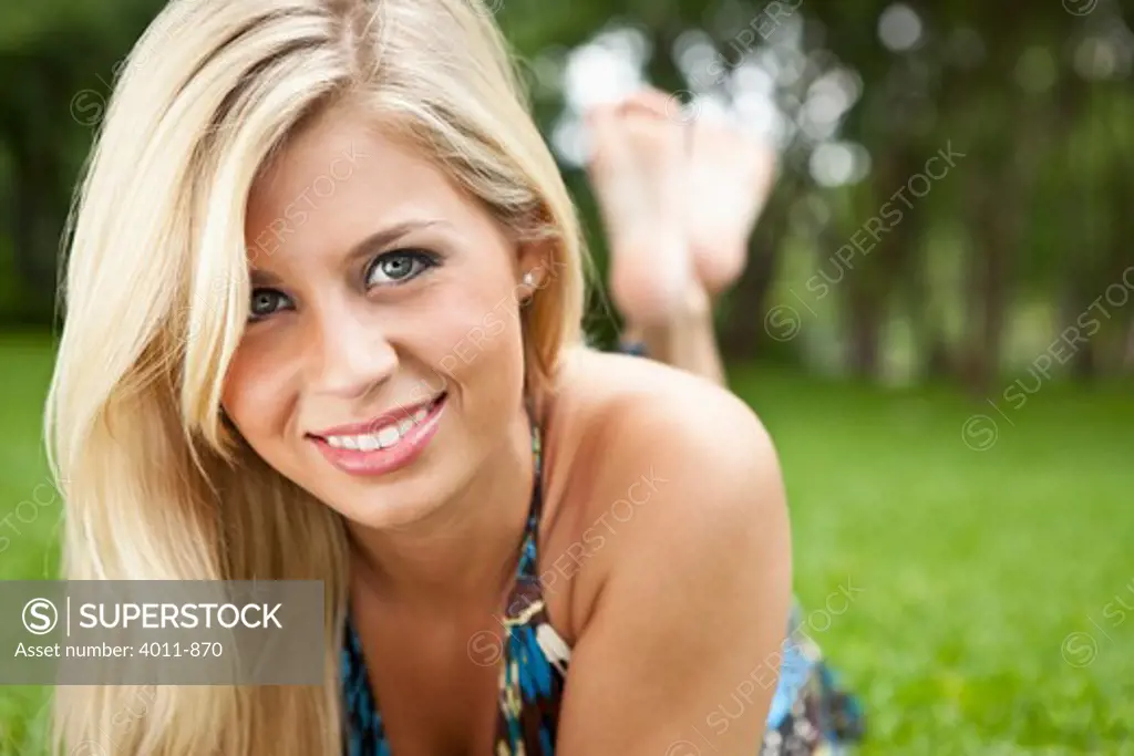 Blonde lying on lawn at park