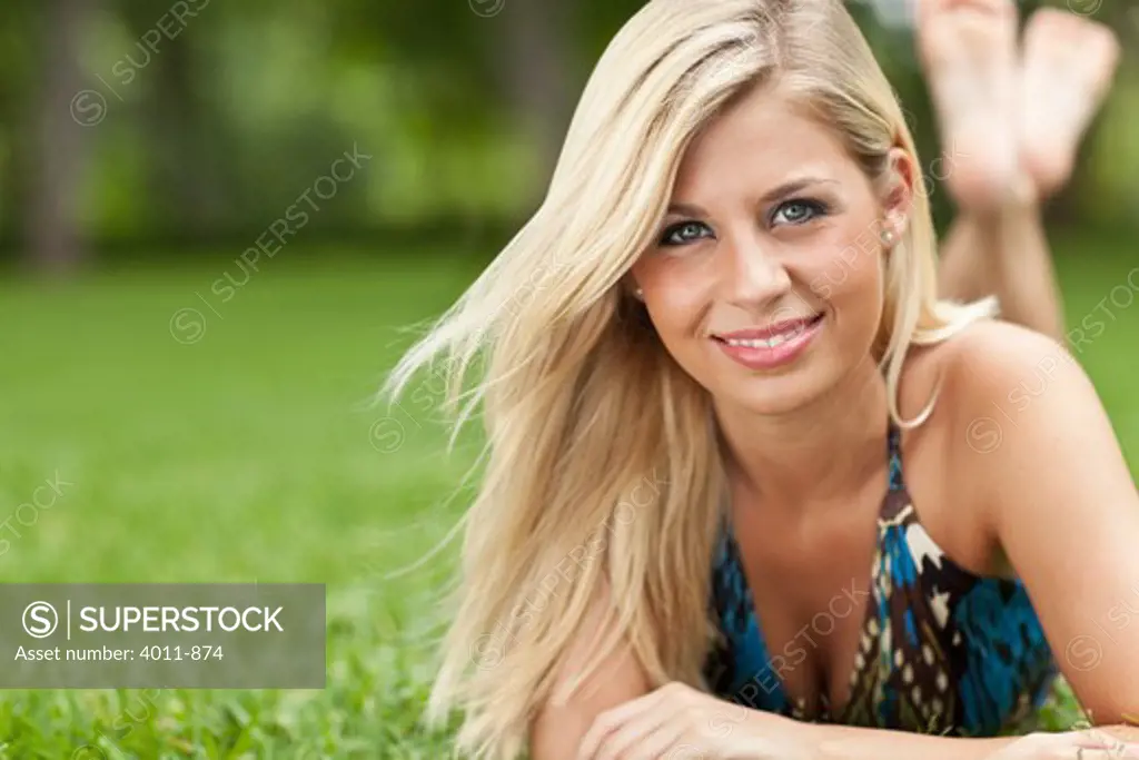 Blonde lying on lawn at park