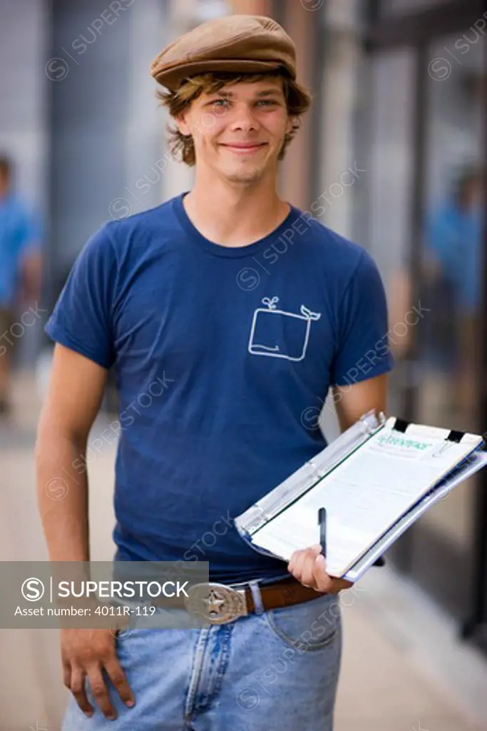 Young man holding a clipboard and smiling, California, USA