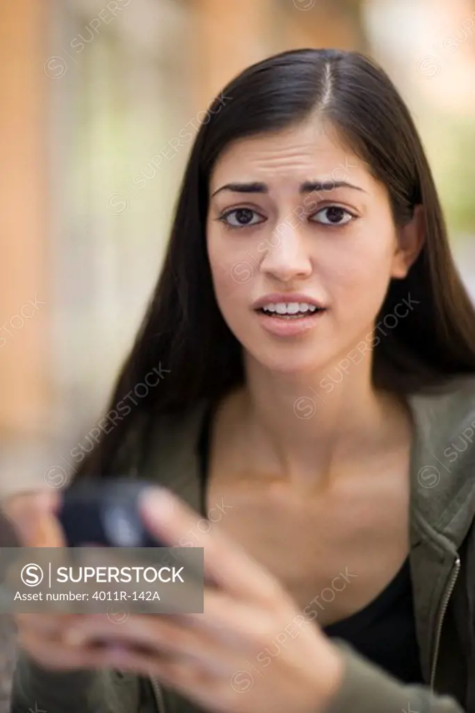 Young woman text messaging on a mobile phone