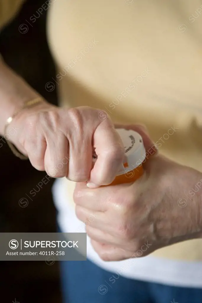Elderly woman trying to open medication