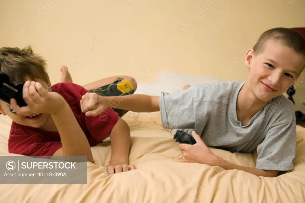 Two boys playing video game and having a playful fight, Brazil