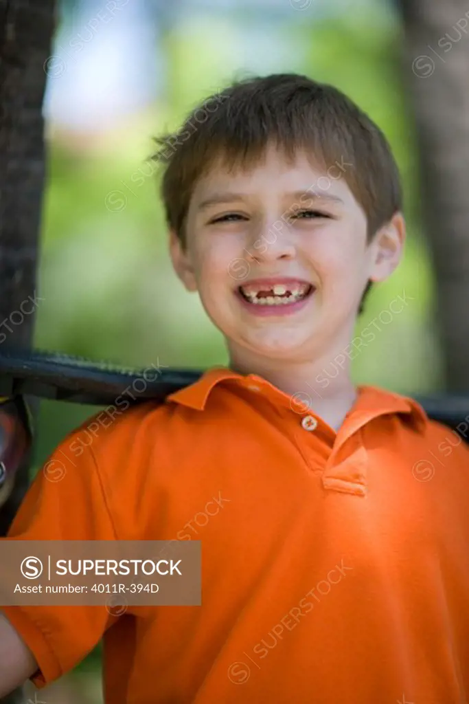 Boy holding a ripstik in a park, Texas, USA