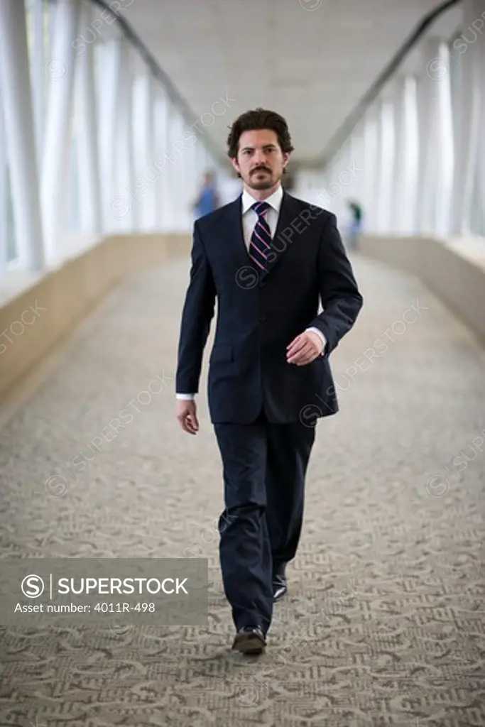 Portrait of businessman walking down corridor