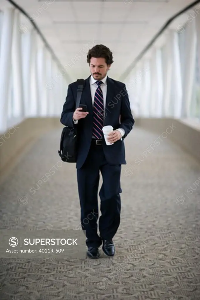 Businessman with coffee cup using mobile phone