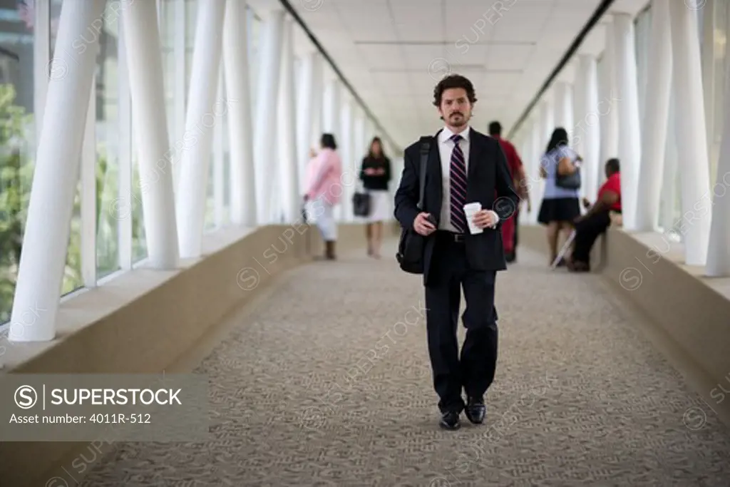 Portrait of businessman holding coffee cup in corridor
