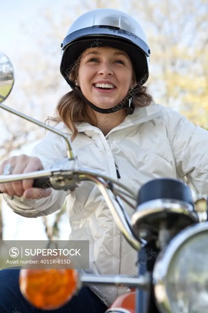 Smiling teenage girl sitting on motorcycle
