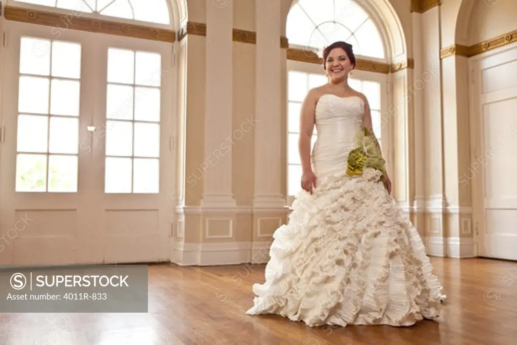 Portrait of smiling bride standing in reception hall