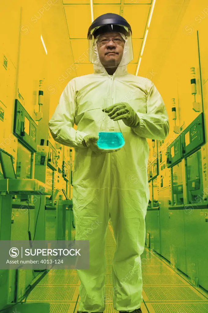 Lab technician holding up liquid solution in clean room