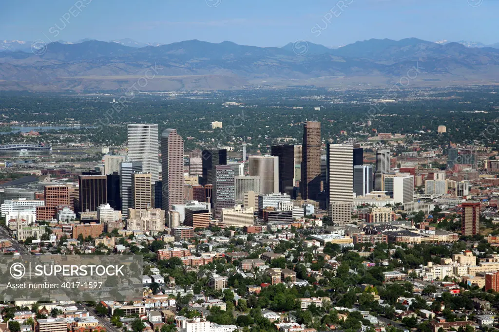 Aerial of Downtown Denver with the Uptown district in foreground and Rocky Mountains in background