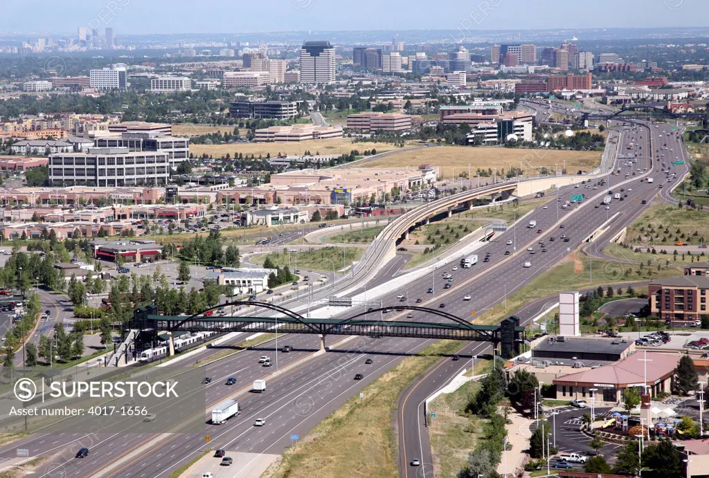 Aeiral of Interstate 25 in Lone Tree Co with the County Line RTD Light Rail Station in foreground and Denver Tech Center and Downtown on the horizon