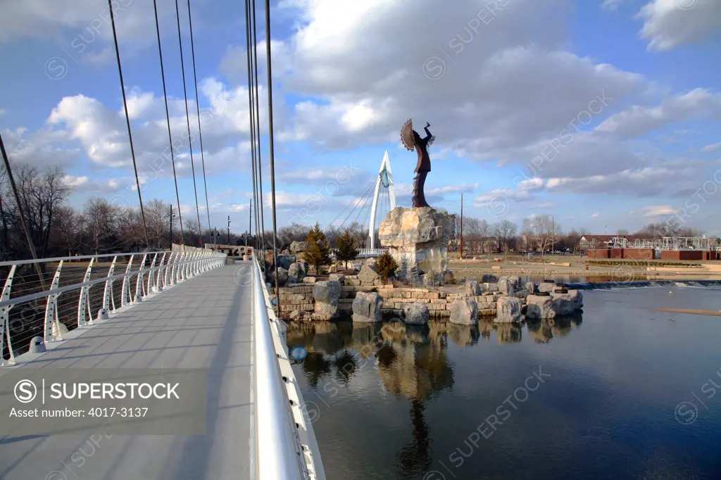 Wichita Riverfront Pedestrian Bridge with Keeper Of The Plains sculpture, Wichita, Kansas, USA