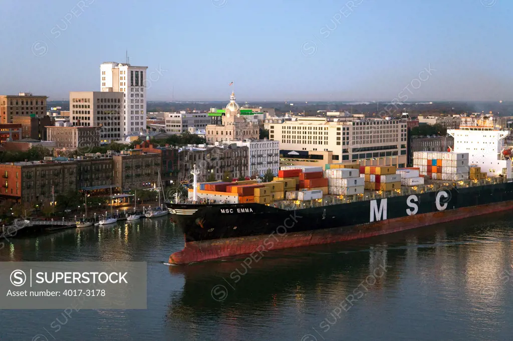 USA, Georgia, Savannah, Container Ship passing through harbor near downtown