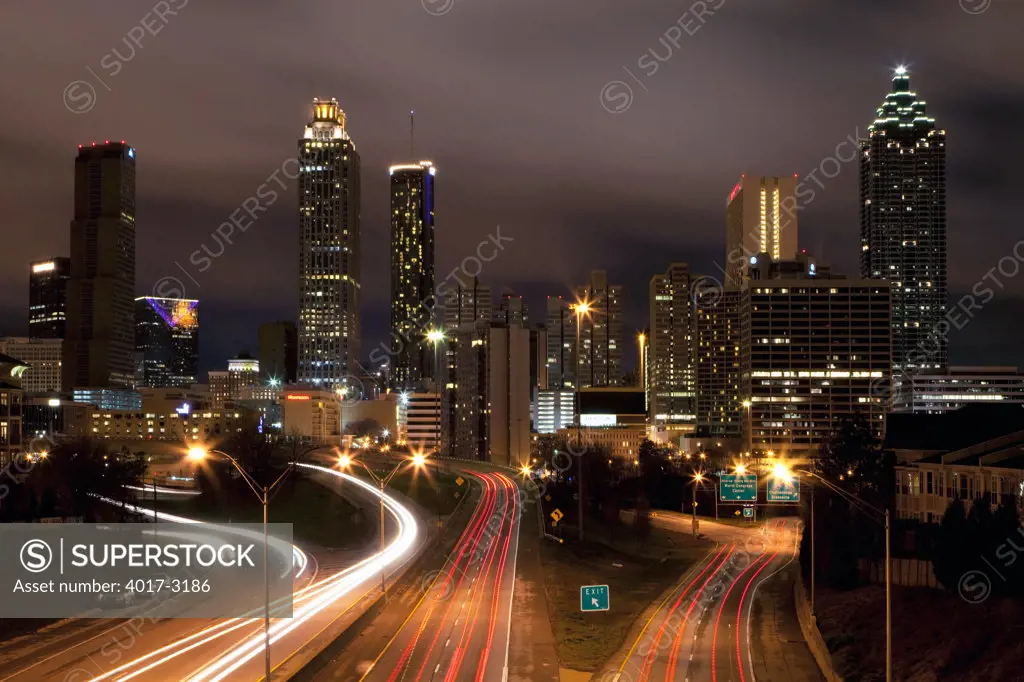 Downtown skyline of Atlanta at dusk with traffic streaming along Freedom Parkway, Georgia, USA