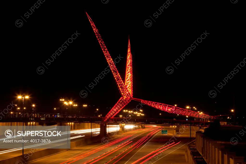 USA, Oklahoma, Oklahoma City, SkyDance Pedestrian Bridge over Interstate 40 lit up in red at night