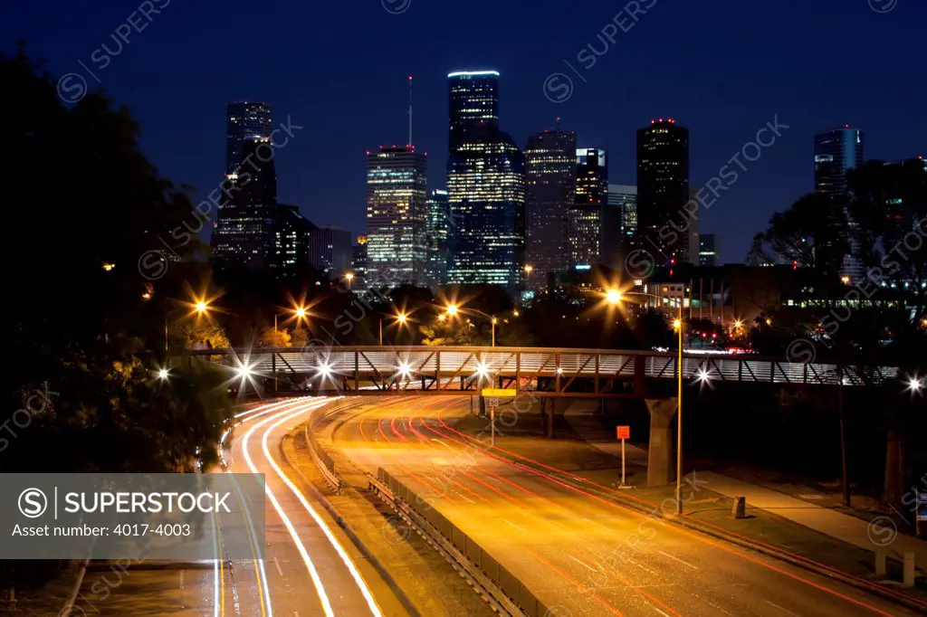 Traffic flowing down Memorial Drive near downtown Houston at night