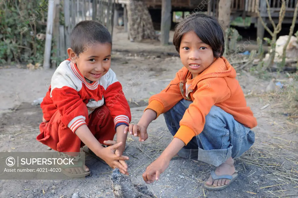 Boys warming hands by a fireplace, Inle Lake, Shan State, Myanmar