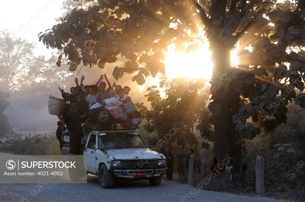 Loaded pick-up truck moving on the road at sunset, Kalaw, Shan State, Myanmar