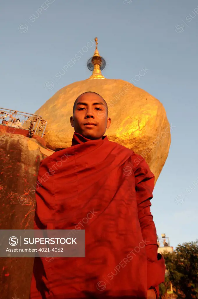 Monk standing before the pagoda on golden rock, Kyaiktiyo Pagoda, Kyaikto, Mon State, Myanmar