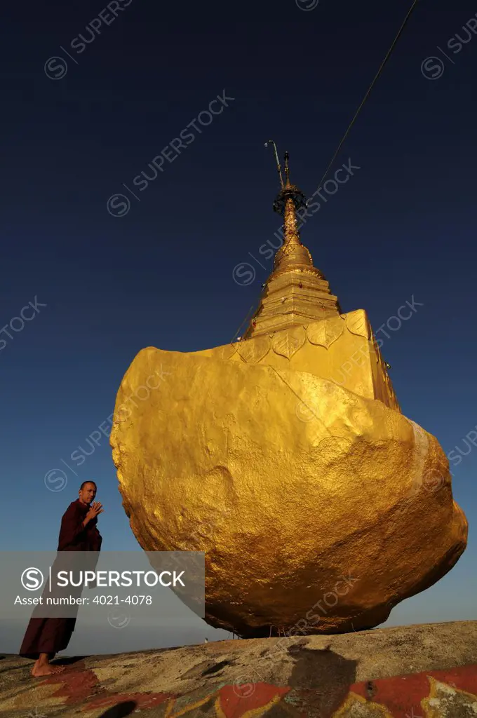 Monk praying in front of a pagoda on the golden rock, Kyaiktiyo Pagoda, Kyaikto, Mon State, Myanmar