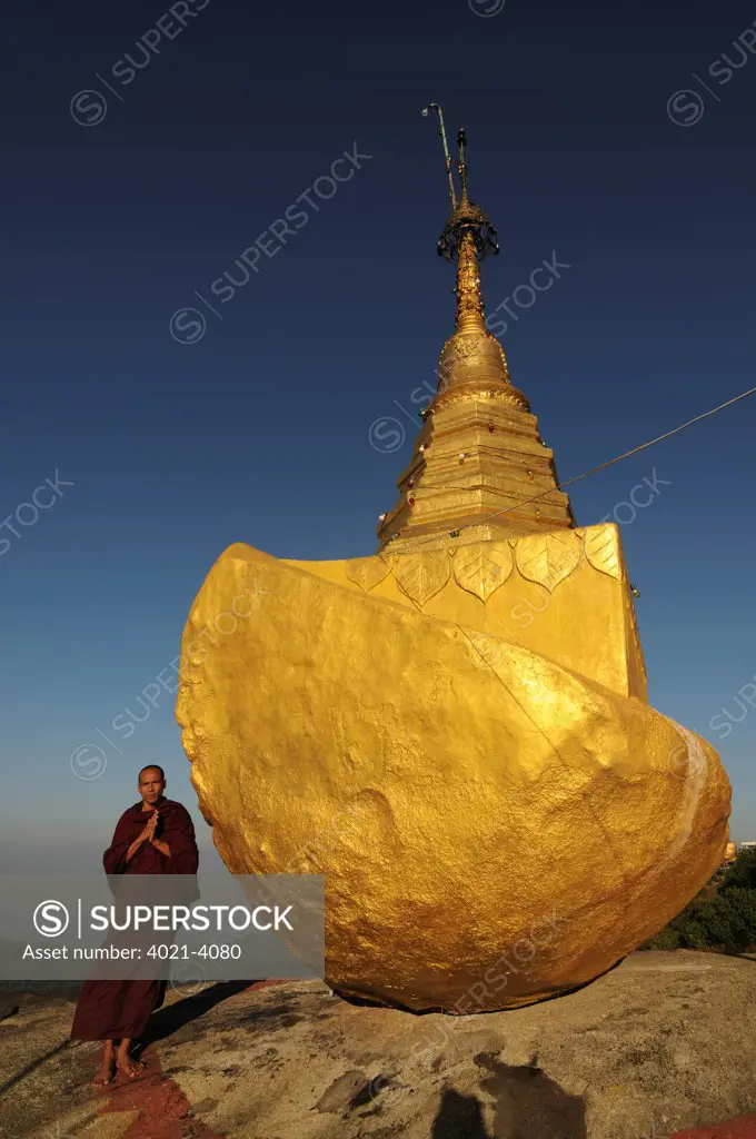 Monk praying in front of a pagoda on the golden rock, Kyaiktiyo Pagoda, Kyaikto, Mon State, Myanmar