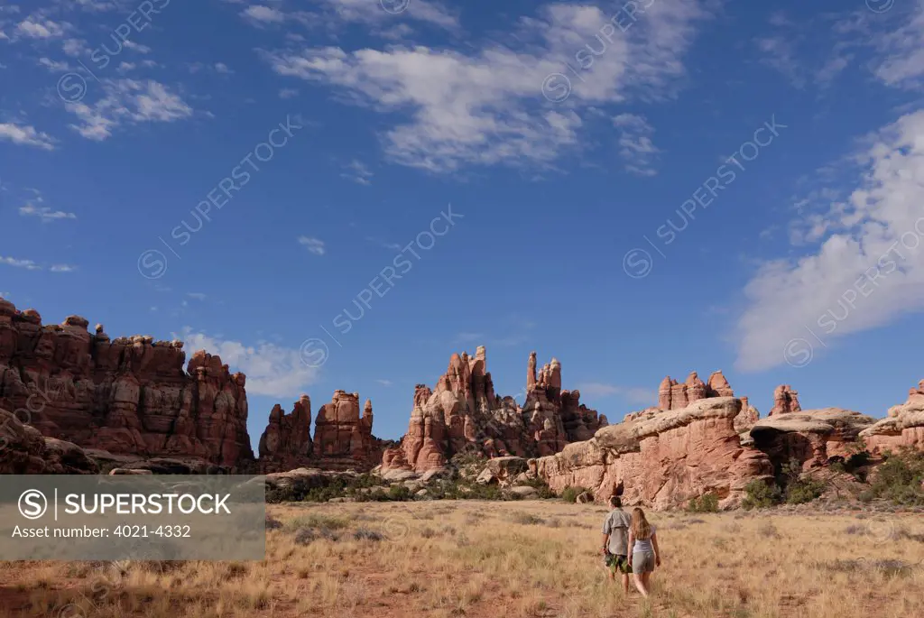 Tourists hiking through the Needles rock formations, Canyonlands National Park, Utah, USA