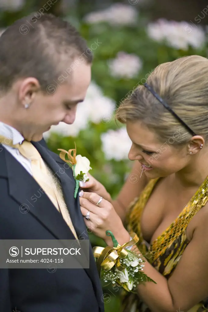 Teenage girl placing a corsage on a teenage boy's coat in senior prom, Seattle Hill-Silver Firs, Snohomish County, Washington State, USA