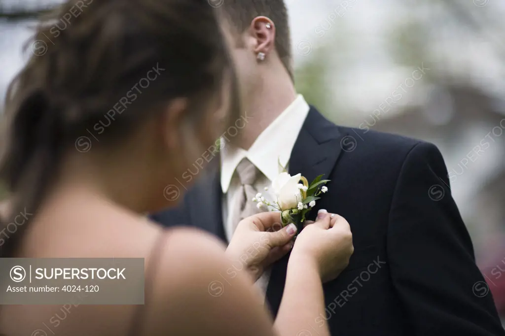 Teenage girl placing a corsage on a teenage boy's coat in senior prom, Seattle Hill-Silver Firs, Snohomish County, Washington State, USA