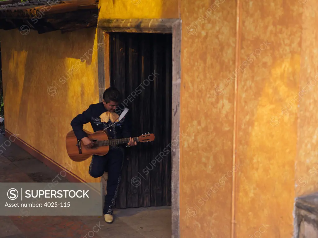 Man playing a guitar at the door, Tequila, Jalisco, Mexico
