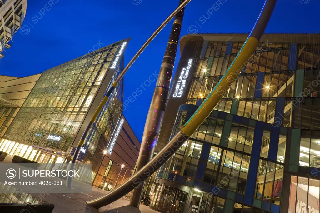 Low angle view of buildings lit up dusk, John Lewis Store, Cardiff Central Library, Cardiff, Wales
