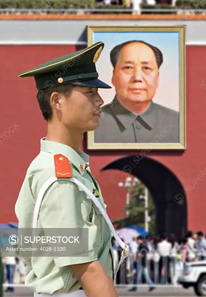 China, Beijing, Tiananmen Square, Gate of Heavenly Peace, Member of the Chinese Army honor guard stands watch at the entrance to the Forbidden City with a portraint of Mao hanging above.