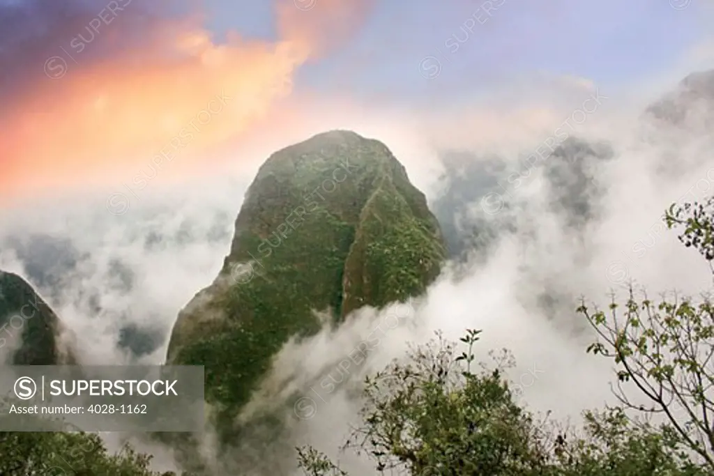 Peru, Machu Picchu, the ancient lost city of the Inca shrouded in mist and clouds at sunrise.