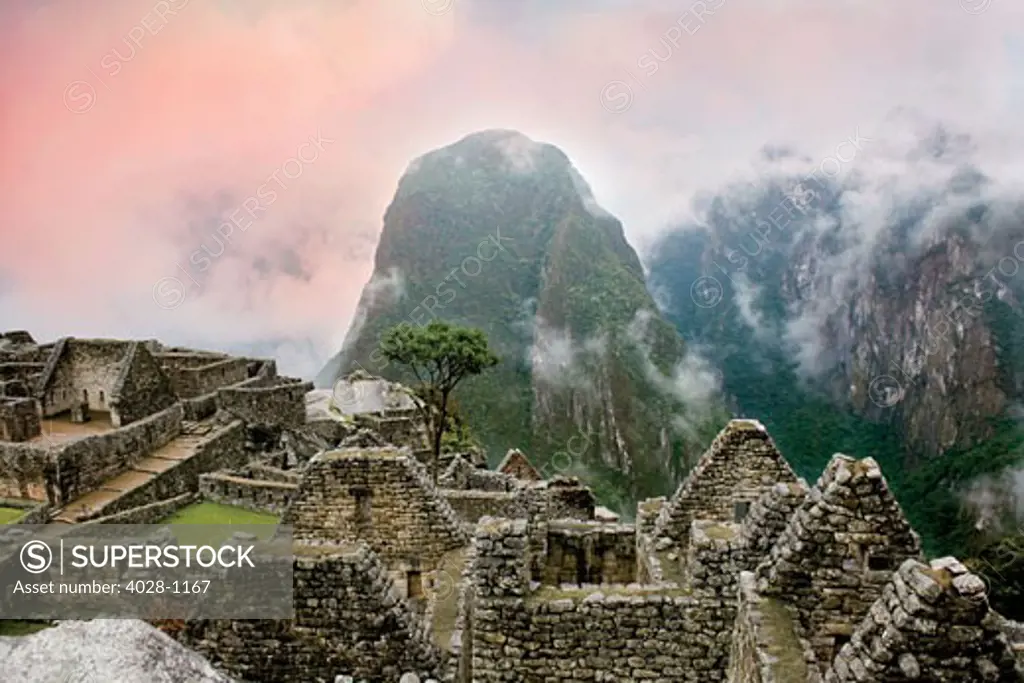 Peru, Machu Picchu, the ancient lost city of the Inca shrouded in mist and clouds at sunrise.