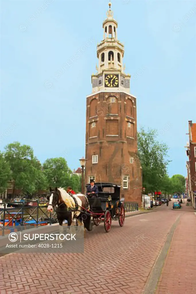 Holland, Amsterdam, Montelbaanstoren Tower, Horse and Carriage on a bridge over a canal. The Netherlands.
