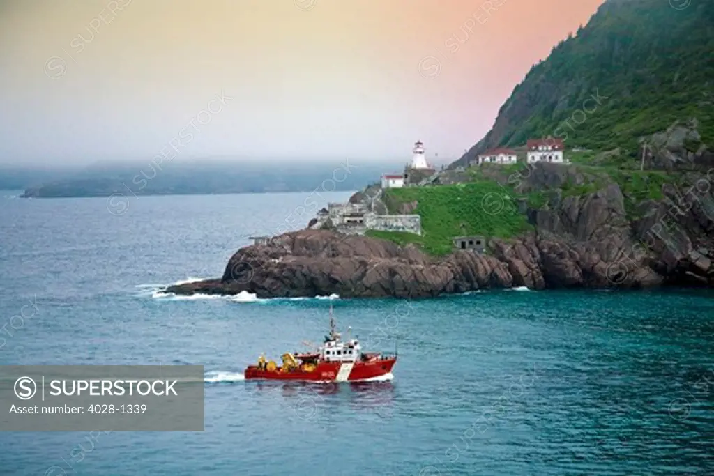 St. John's, Newfoundland, Canada, a Canadian Coat Guard boat sails by historic Fort Amherst between the Narrows into St. John's Harbor