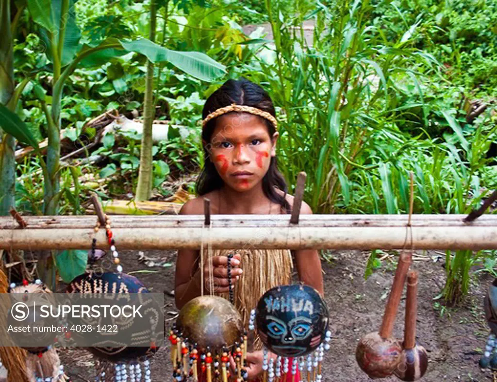 Iquitos, Peru, A girl from an Amazon tribe in Peru or Brazil sells hand made traditonal jewlery to those that visit her village