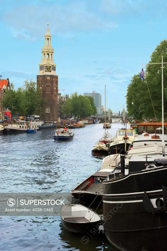 Holland, Amsterdam, Montelbaanstoren Tower, boats along canal. The Netherlands.