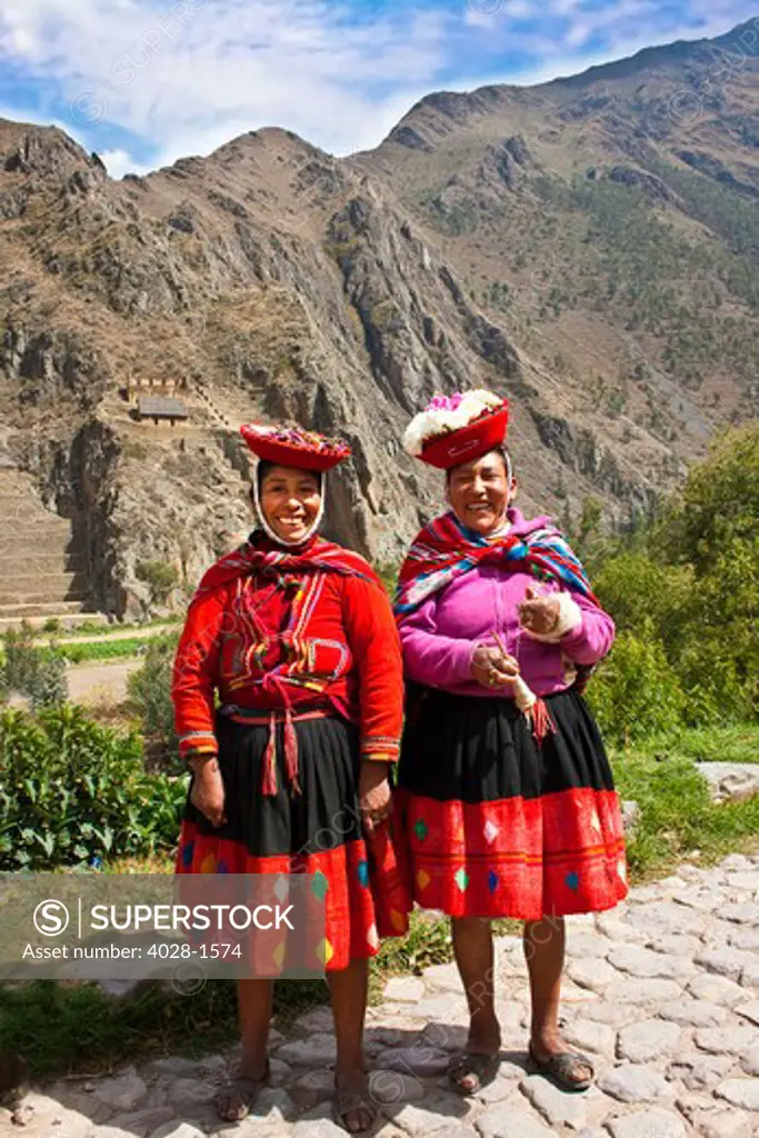 Ollantaytambo, Peru, Local women dressed in traditional clothing pose near the Incan ruins of Ollantaytambo, in the Sacred Valley of Peru