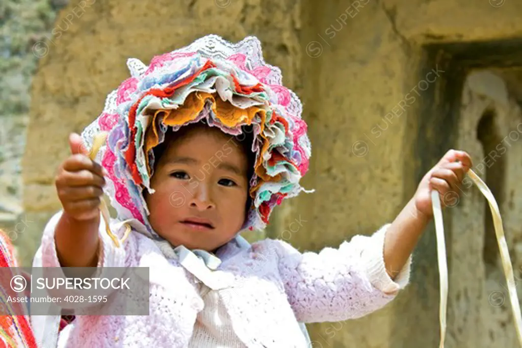 Ollantaytambo, Peru, a baby in traditional clothes reaches out to her mother