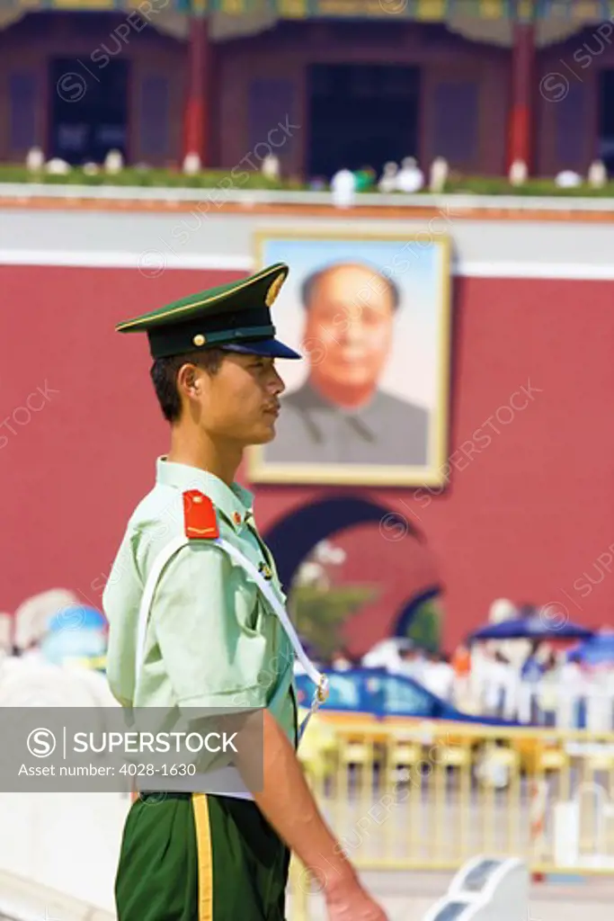 China, Beijing, Tiananmen Square, Gate of Heavenly Peace, Member of the Chinese Army honor guard stands watch at the entrance to the Forbidden City with a portraint of Mao hanging above.