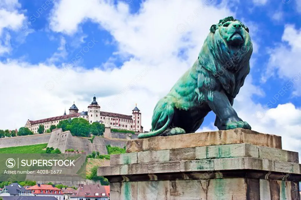 Wurzburg, Bavaria, Germany, a lion statue guards the bridge over the Main River leading to the Marienberg Fortress (Festung Marienberg)