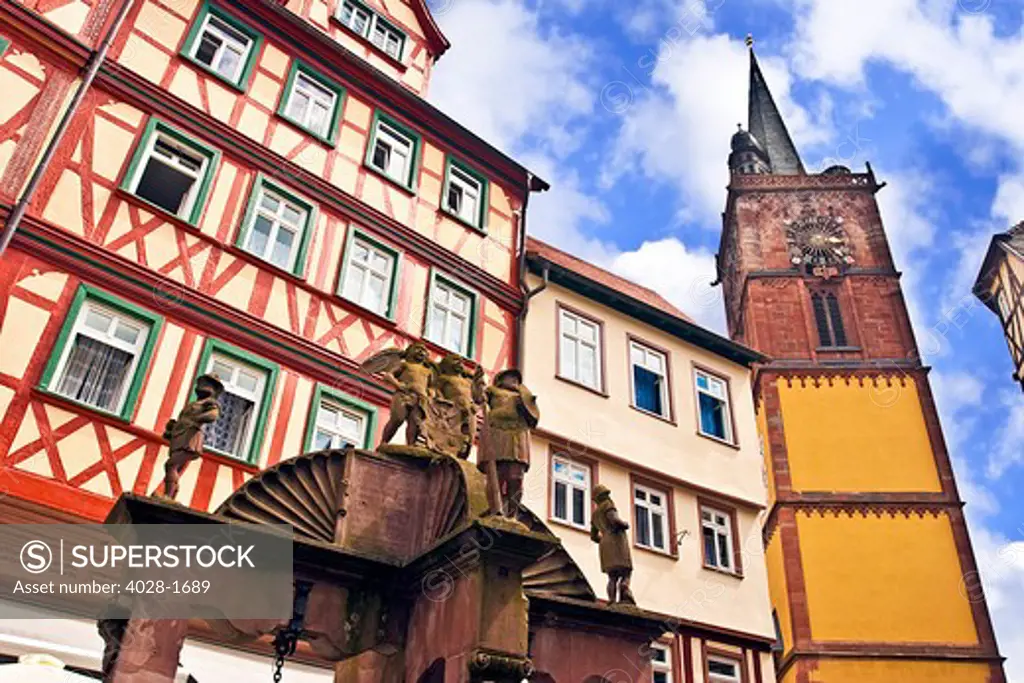 Wertheim, Franconia, Germany, a medieval water well in front of Cross Timbered Houses and a clock tower