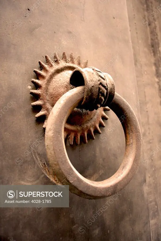 Italy, Tuscany, Florence, ancient medieval metal door with metal door knocker, close-up