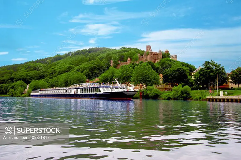 A River cruise ship docked outside of Wertheim, Germany with Wertheim Castle in the background