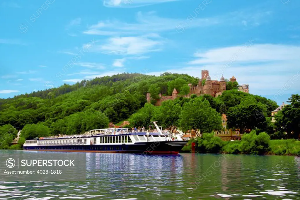 A River cruise ship docked outside of Wertheim, Germany with Wertheim Castle in the background