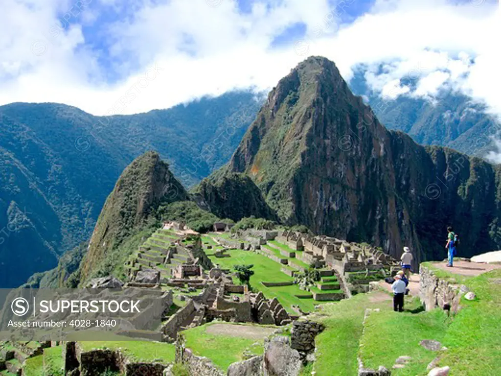 Tourists take in the awesome vista of ancient lost city of the Inca, Machu Picchu in the Sacred Valley of Peru, South America