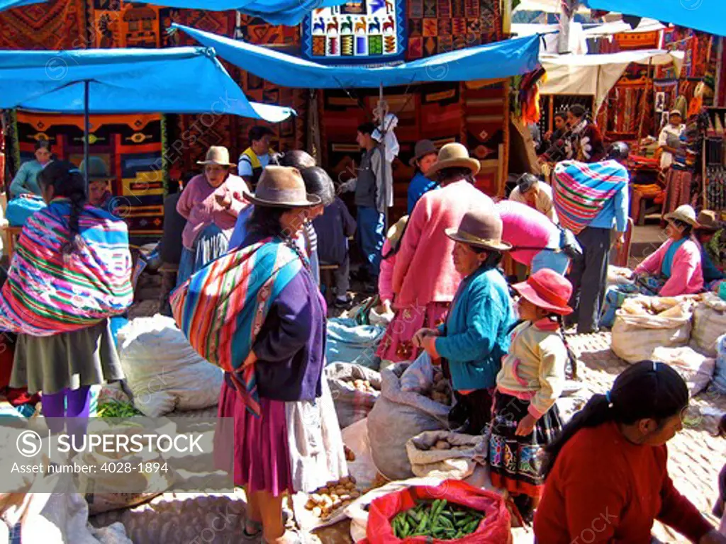 The market in Pisac, Peru where local women sell their wares from clothing and blankets to vegetables and fruit in the Sacred Valley of Peru.