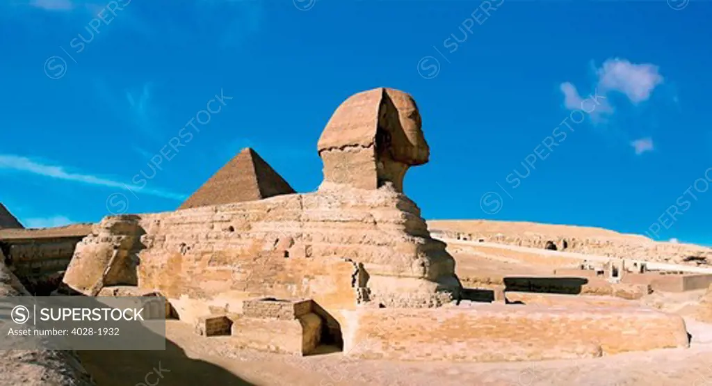 Egypt, Cairo, The Sphinx sits before and the Great Pyramids.