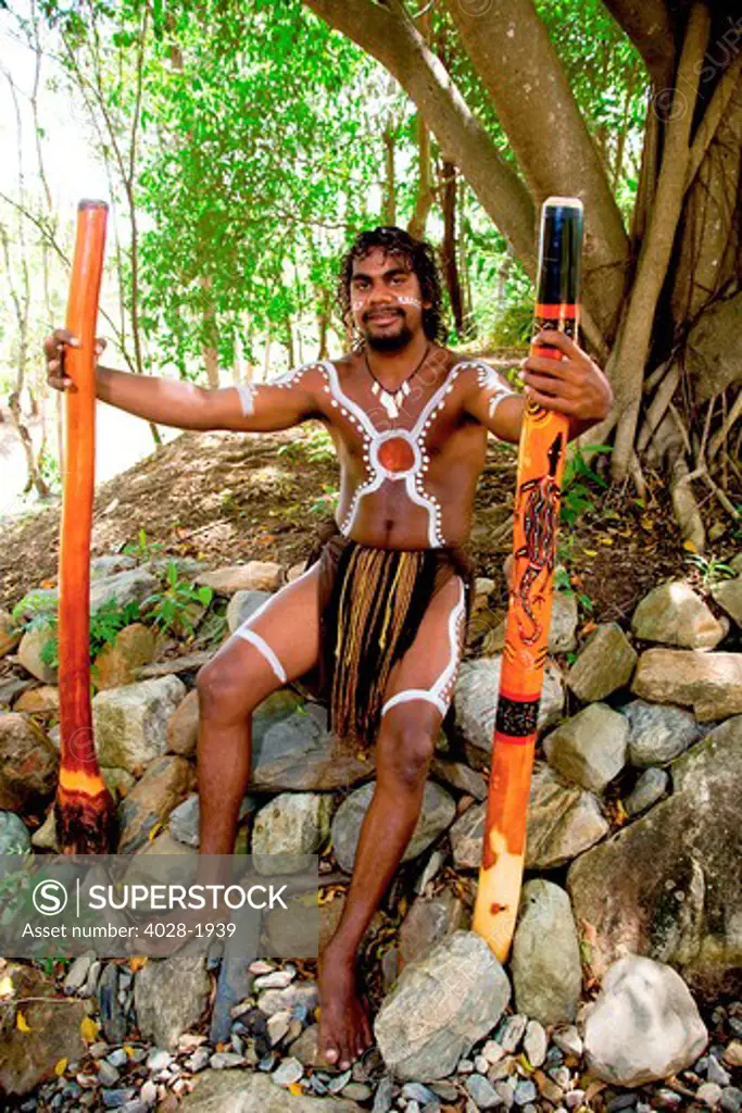 Cairns, Australia,  Aborigine man smiling and holding  didgeridooss