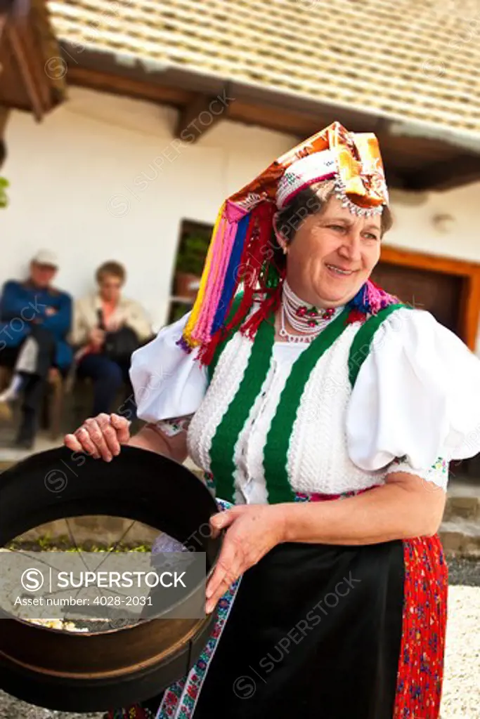 Woman Dressed in Traditional Costume with a cooking basket, Holloko, Hungary